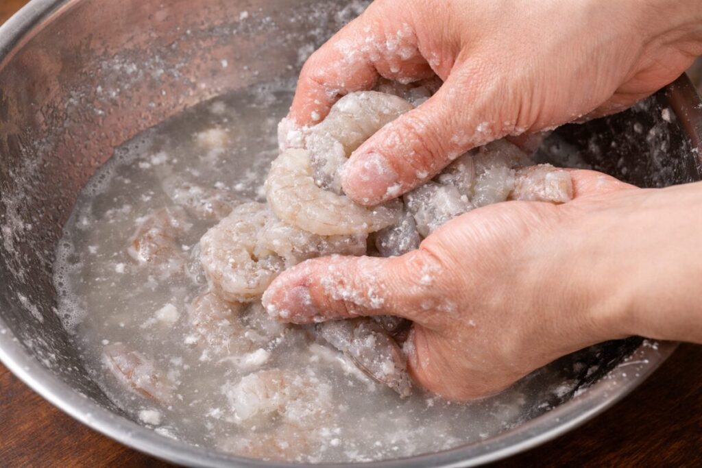 むきエビを塩と片栗粉でもみ洗いする、エビチリの下処理