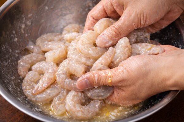 エビチリ用のむき海老に下味をつけている様子