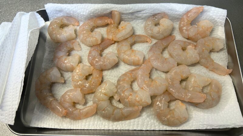 キッチンペーパーで水分を拭き取り、下処理を終えたエビ