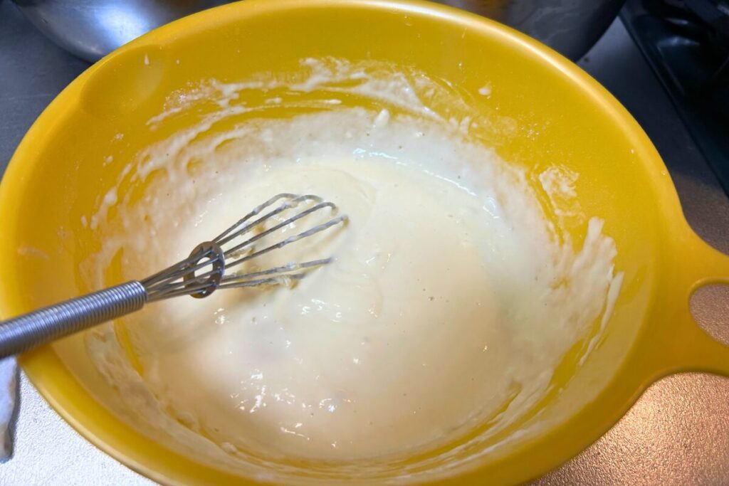 薄力粉・片栗粉・卵・水を合わせた衣をボウルで混ぜている様子