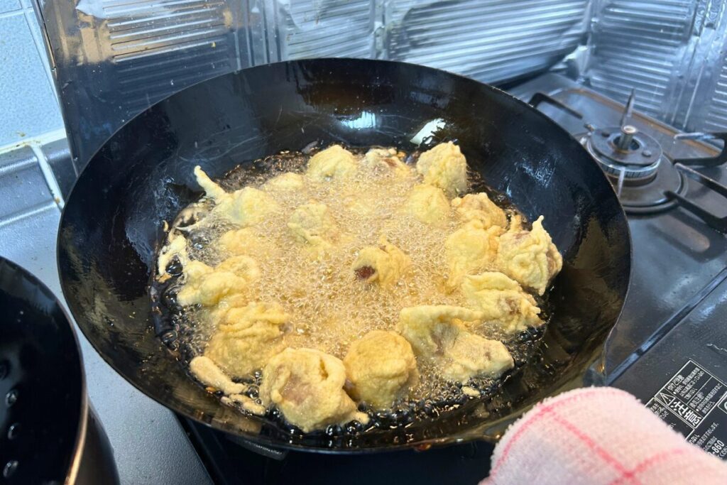 全量の豚肉をまとめて高温で二度揚げしている様子
