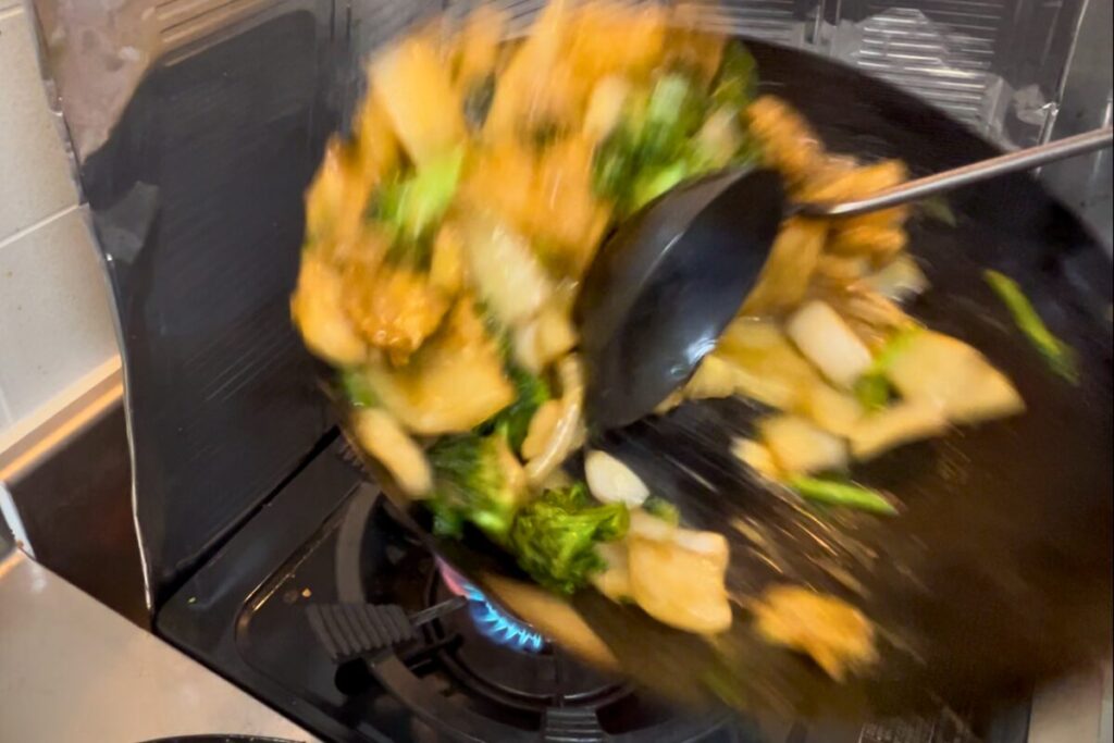 お玉の背で食材を押すお玉押しの動作