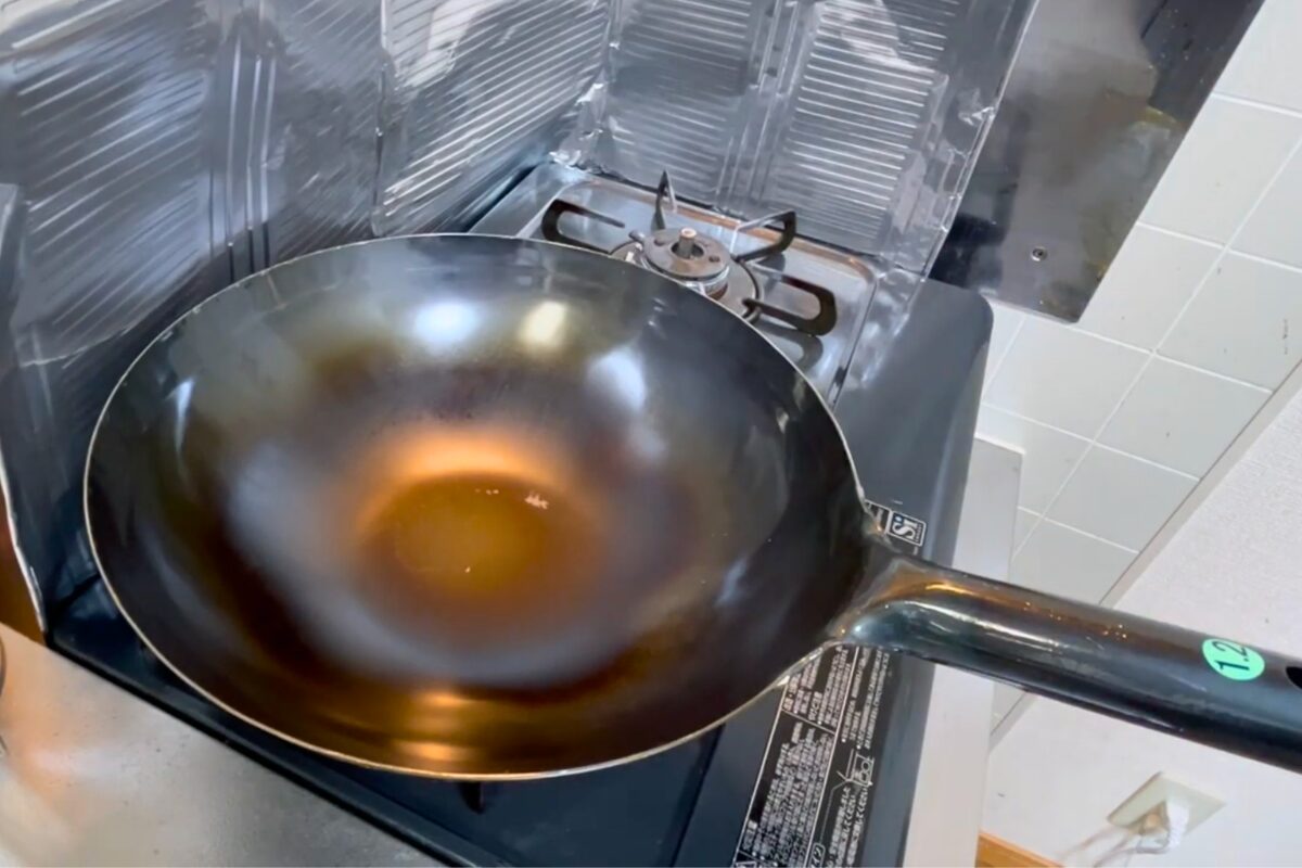 山田工業所 中華鍋30cmの空焼き途中。鍋底中央からオレンジ色に変化が広がっている