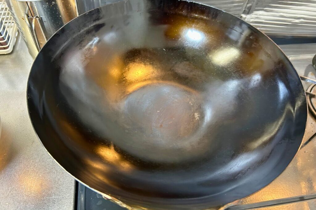 油ならし後の山田工業所 中華鍋30cmの内側。全体に黒いツヤが出て、油膜が形成されている