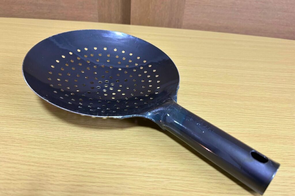 鉄製ザーレン（新品）を斜めから見た全体像。椀状の網と長い柄がはっきり分かる