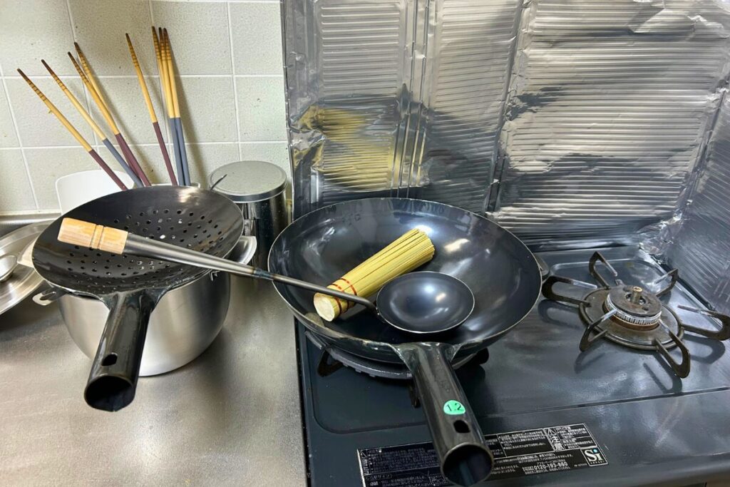 新品の中華鍋・ザーレン・お玉・ササラを並べた道具一式。これから育てていく状態