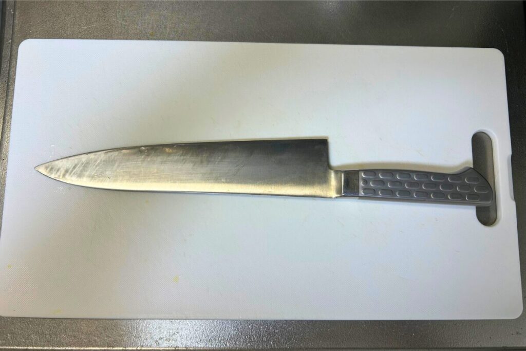 まな板の上に置いた刃渡り240mmの牛刀。長辺に無理なく収まっている