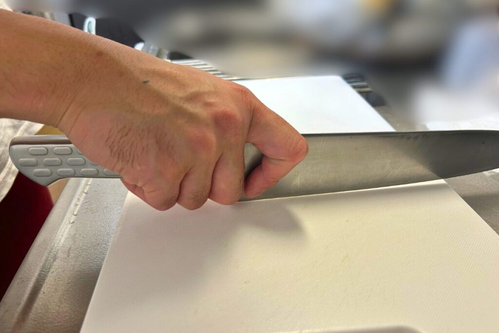 柄を握り、刃元を指で挟んだ牛刀の持ち方全体