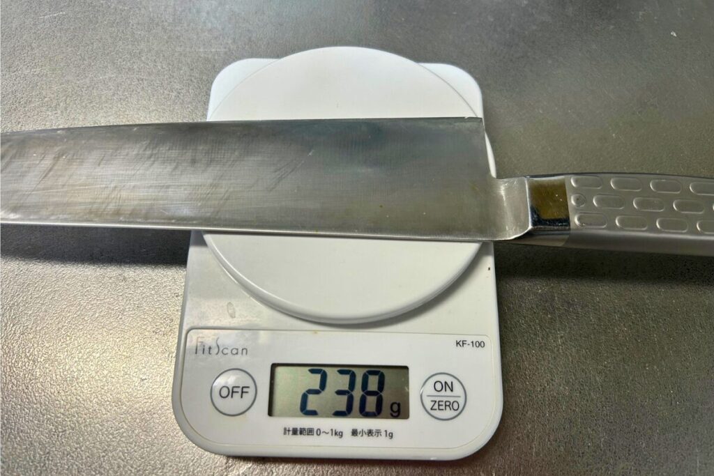 キッチンスケールに載せた自宅の牛刀。表示は238g