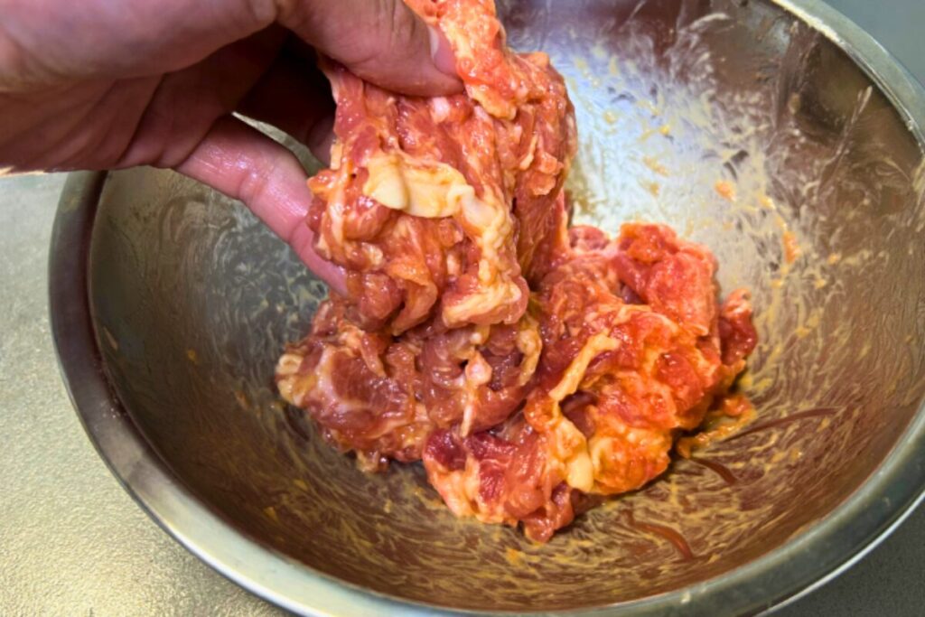 肉に卵・片栗粉・油を揉み込んでチャンをしている様子