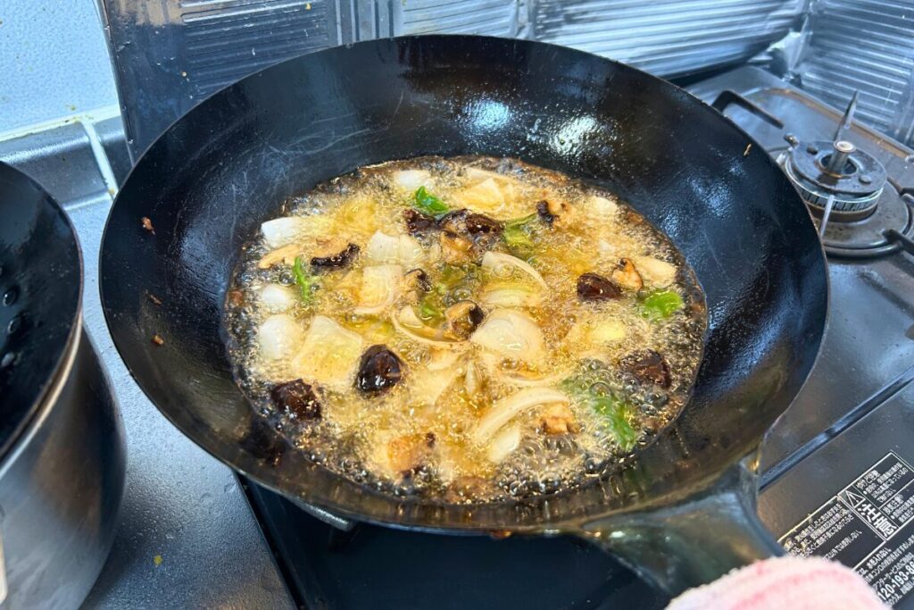干し椎茸・玉ねぎ・ピーマンを油通ししている様子