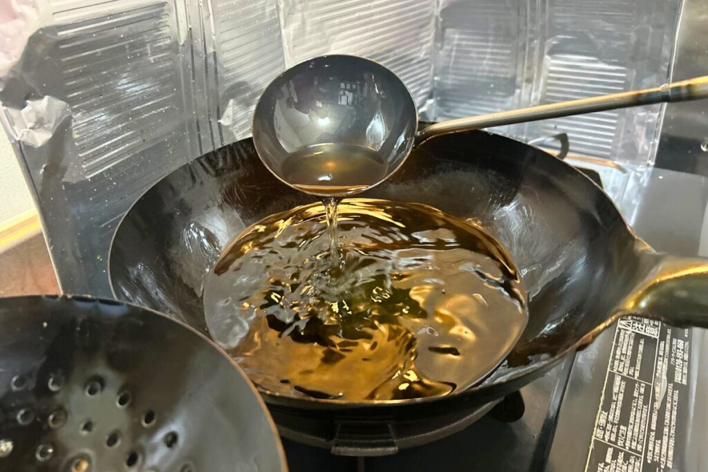 油を鍋に注ぎ、適温を見極めている様子