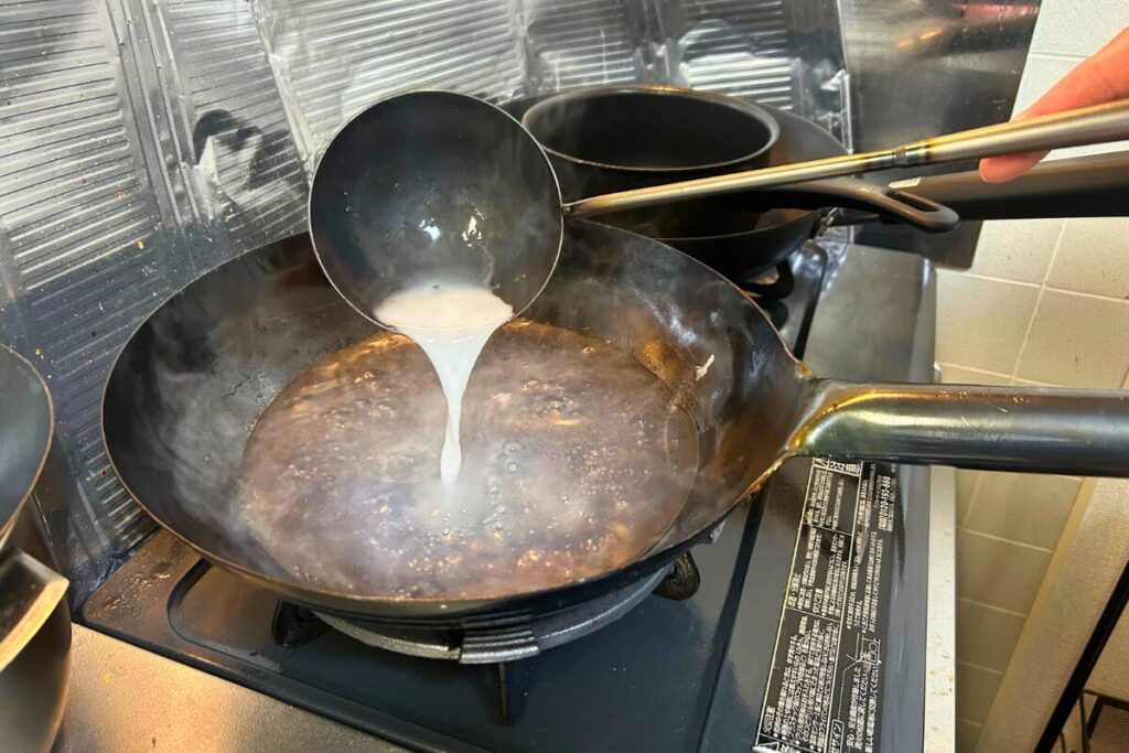 お湯に水溶き片栗粉を注いでとろみを付ける練習の様子