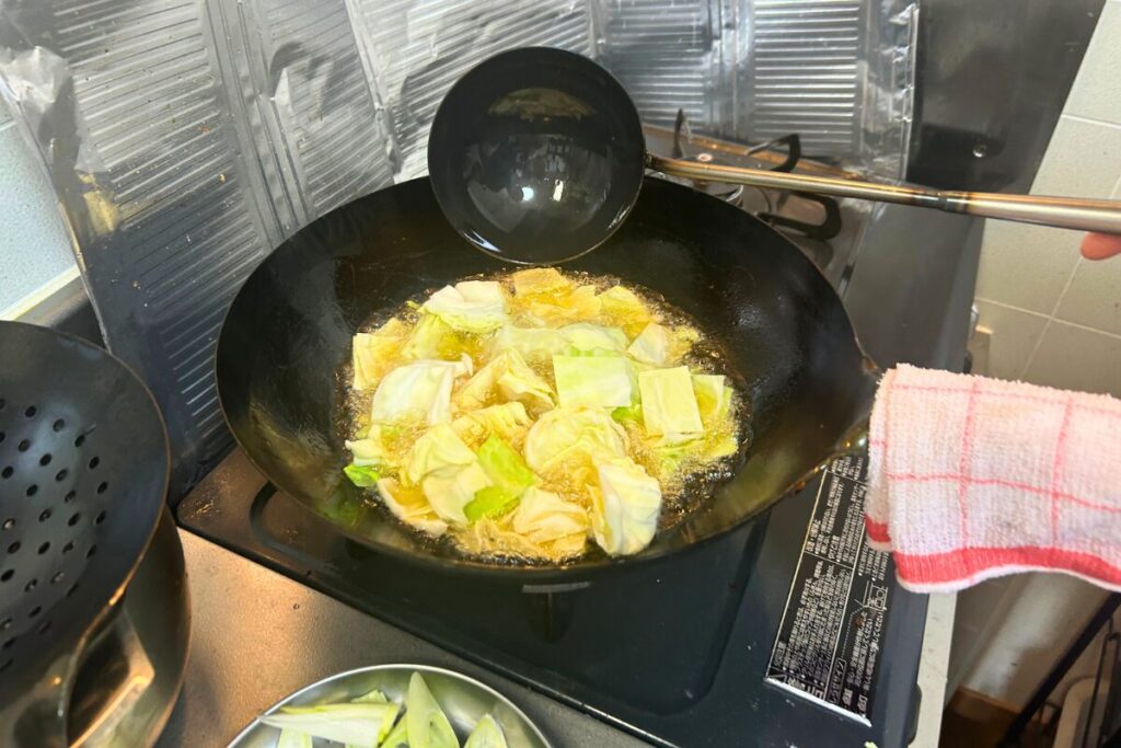 大きめにざく切りしたキャベツを油通ししている様子(1/2)