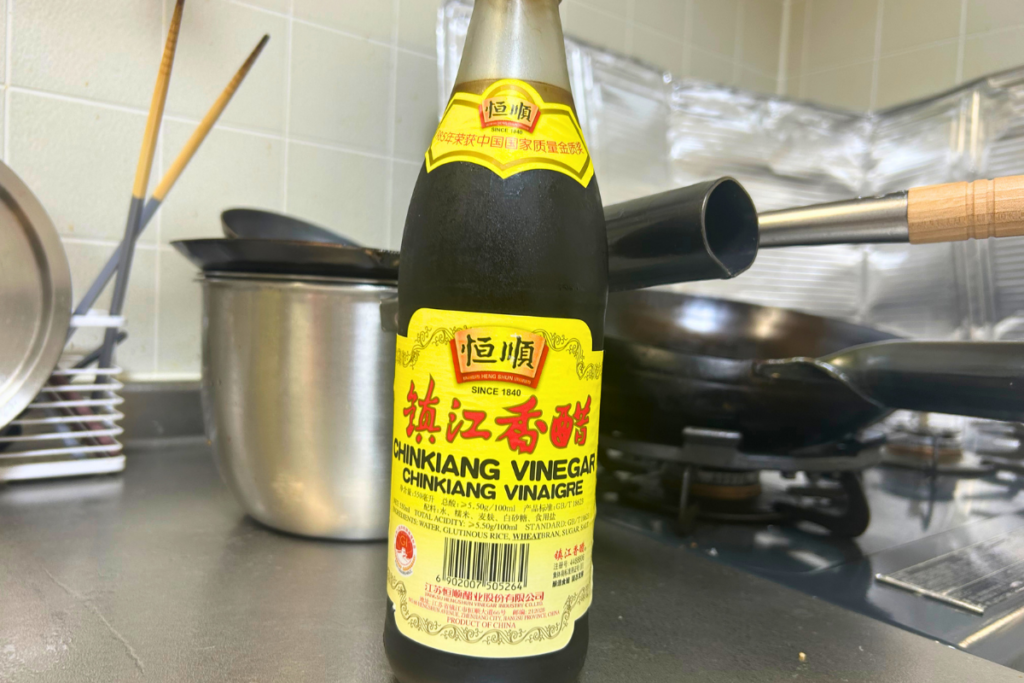 中華鍋の脇に置かれた鎮江香醋のボトル