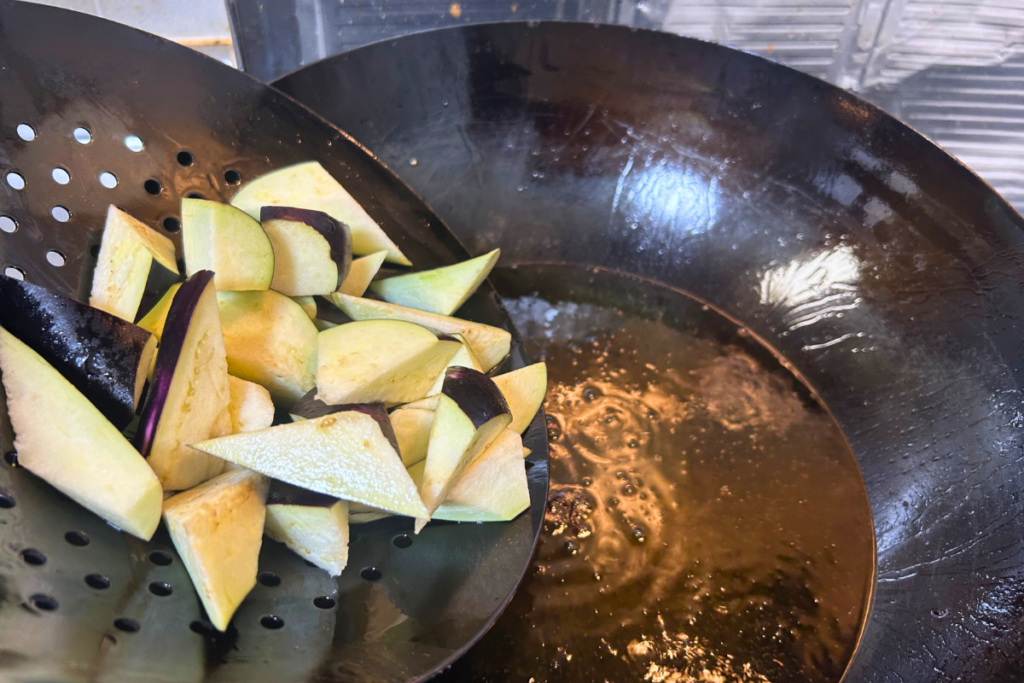 煙がしっかり立つ高温の油に、なすを入れる瞬間
