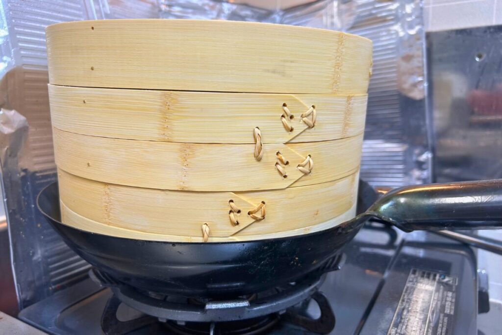 30cmの中華鍋に竹せいろ27cmを直接のせ、鍋のフチから沈んだ位置で止まった状態