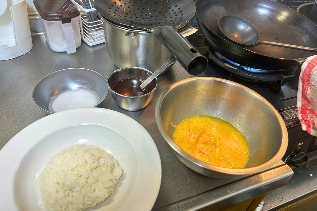 天津飯を作る前に、中華鍋・合わせ調味料・卵液・ご飯を並べて用意した状態