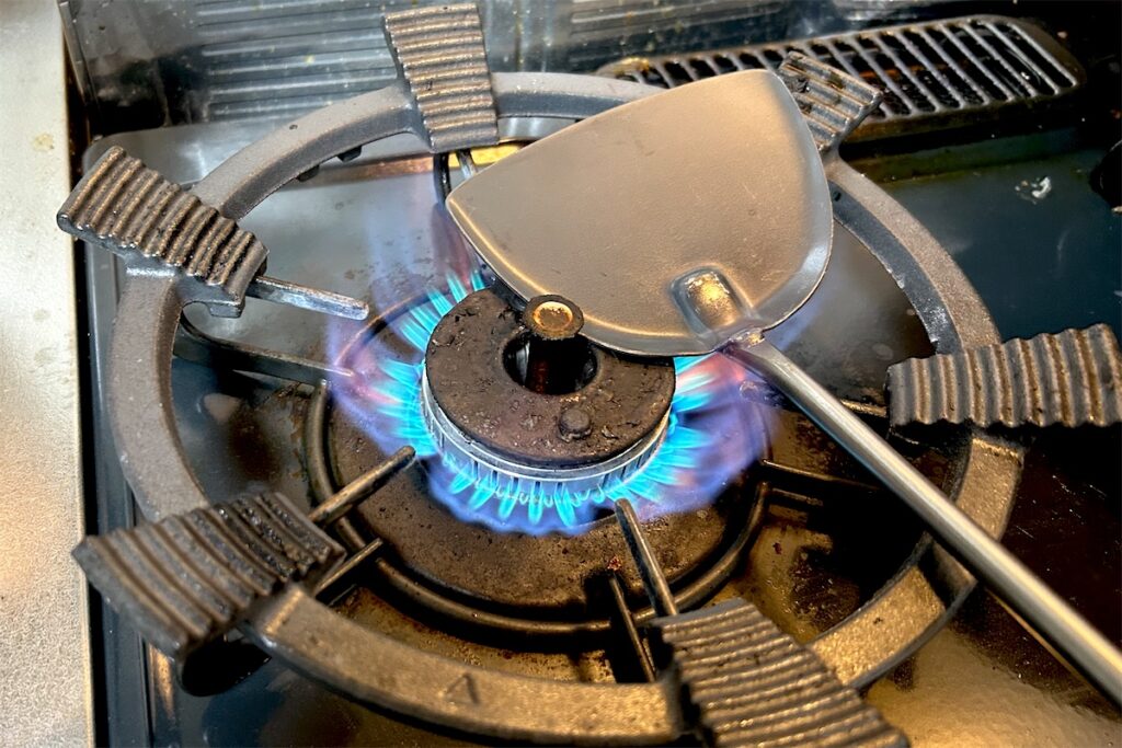 ガスの火で、中華ヘラのヘラ部分だけを空焼きしているところ