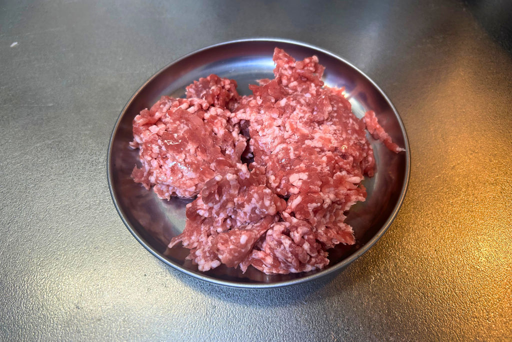 ステンレスの皿にのせた、炸醤の材料の生の豚ひき肉