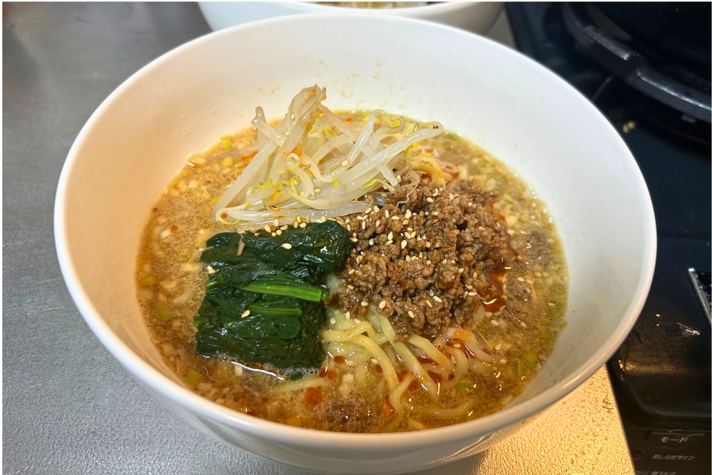 ごまのスープに中太麺、もやし、ほうれん草、肉味噌をのせ、ラー油と白ごまで仕上げた汁ありの担々麺