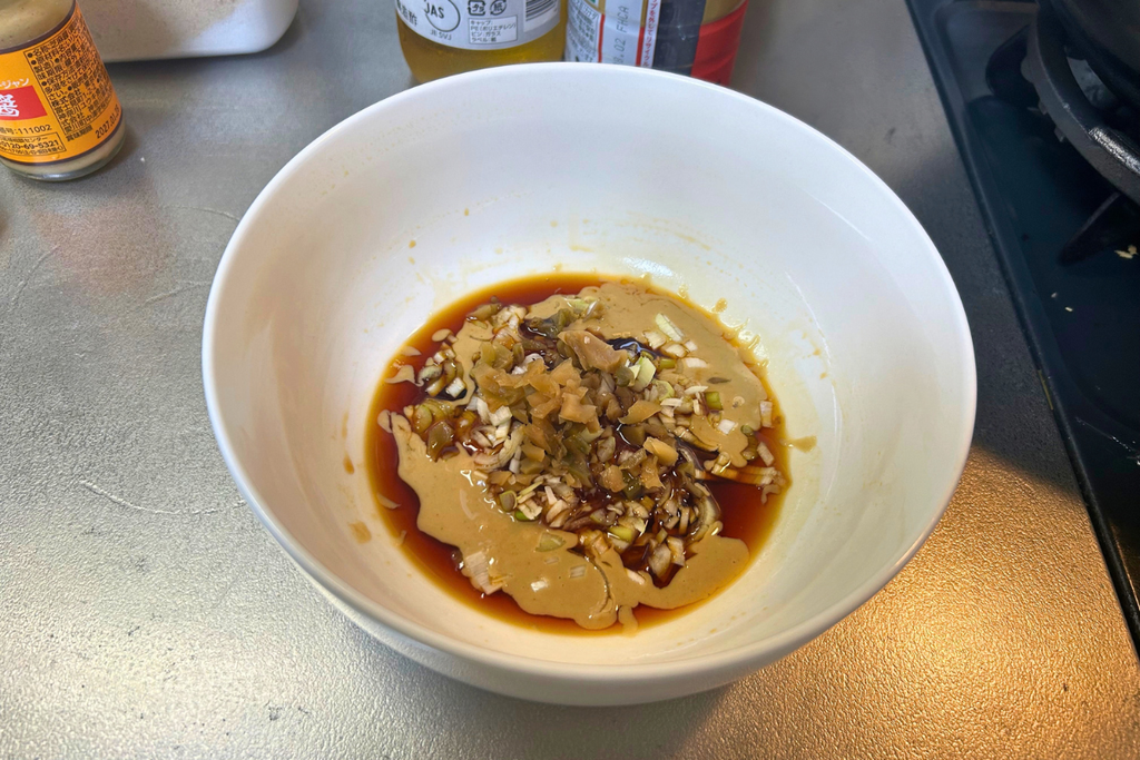 白いどんぶりに芝麻醤、醤油、葱花、搾菜を入れた、スープで割る前のタレ