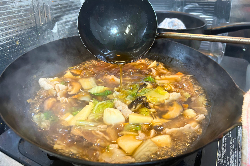 仕上げに、お玉から香味油を回しかける様子。