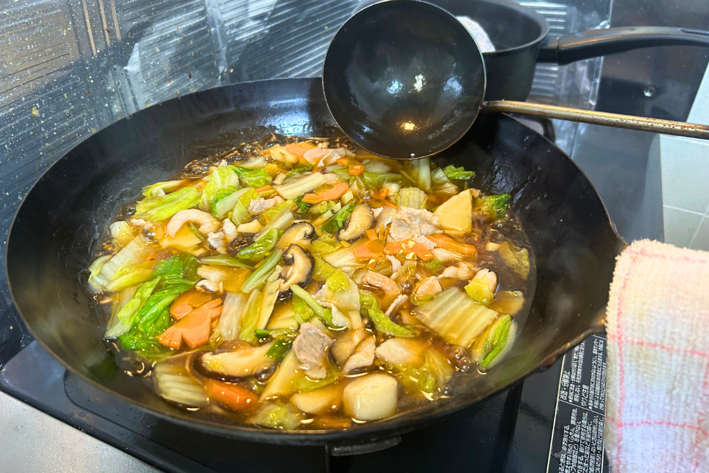 具材を戻し、軽く沸騰した状態で煮ている八宝菜。