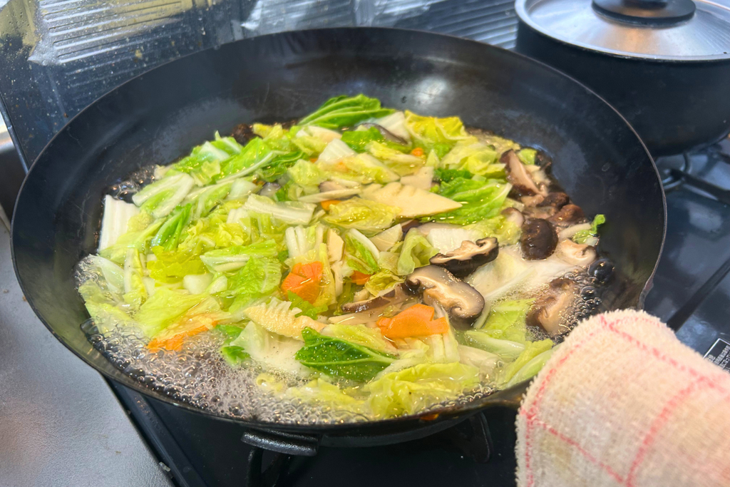 中華鍋の湯で、白菜・人参・筍・干し椎茸を煨する様子。