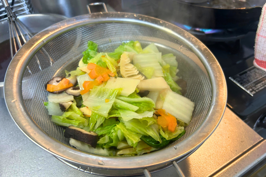 煨して、ザルに上げた野菜。